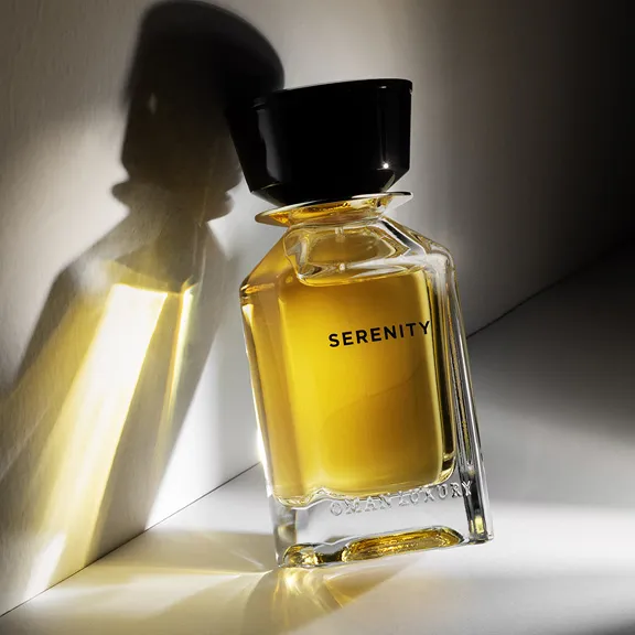 Parfümflakon SERENITY: goldgelb, mit schwarzem Verschluss und starkem Schatten.